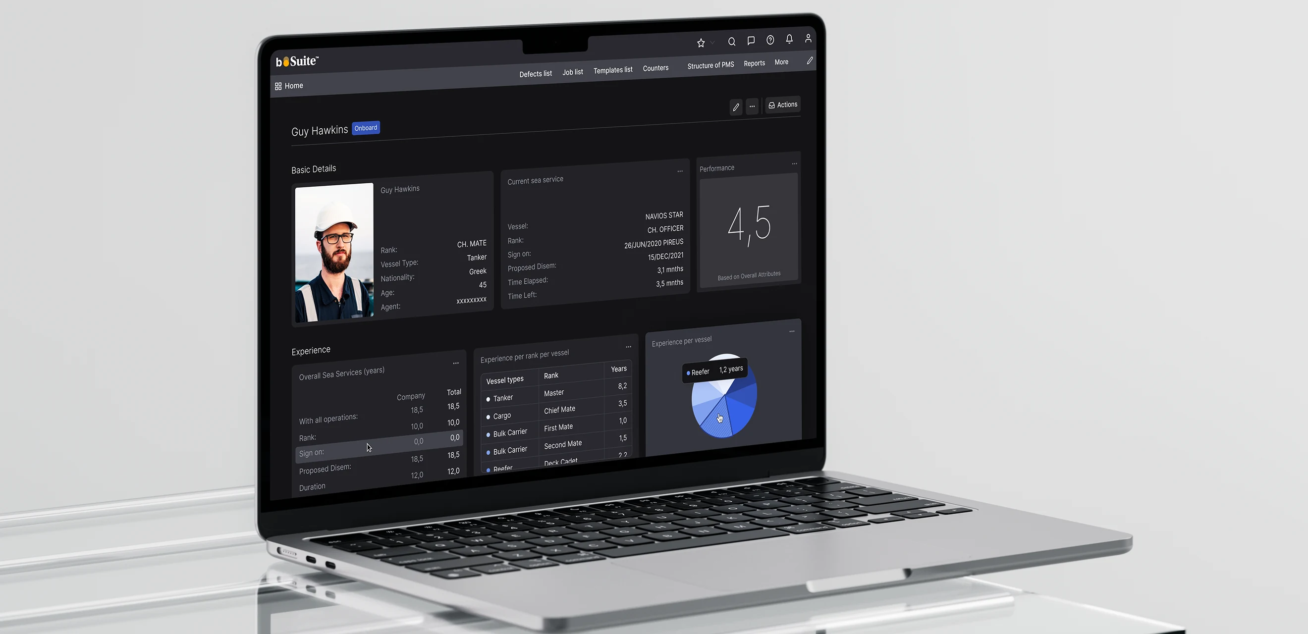A laptop on a glass desk showing a seafarer profile in the dark theme - photograph, rank, current vessel and a performance score