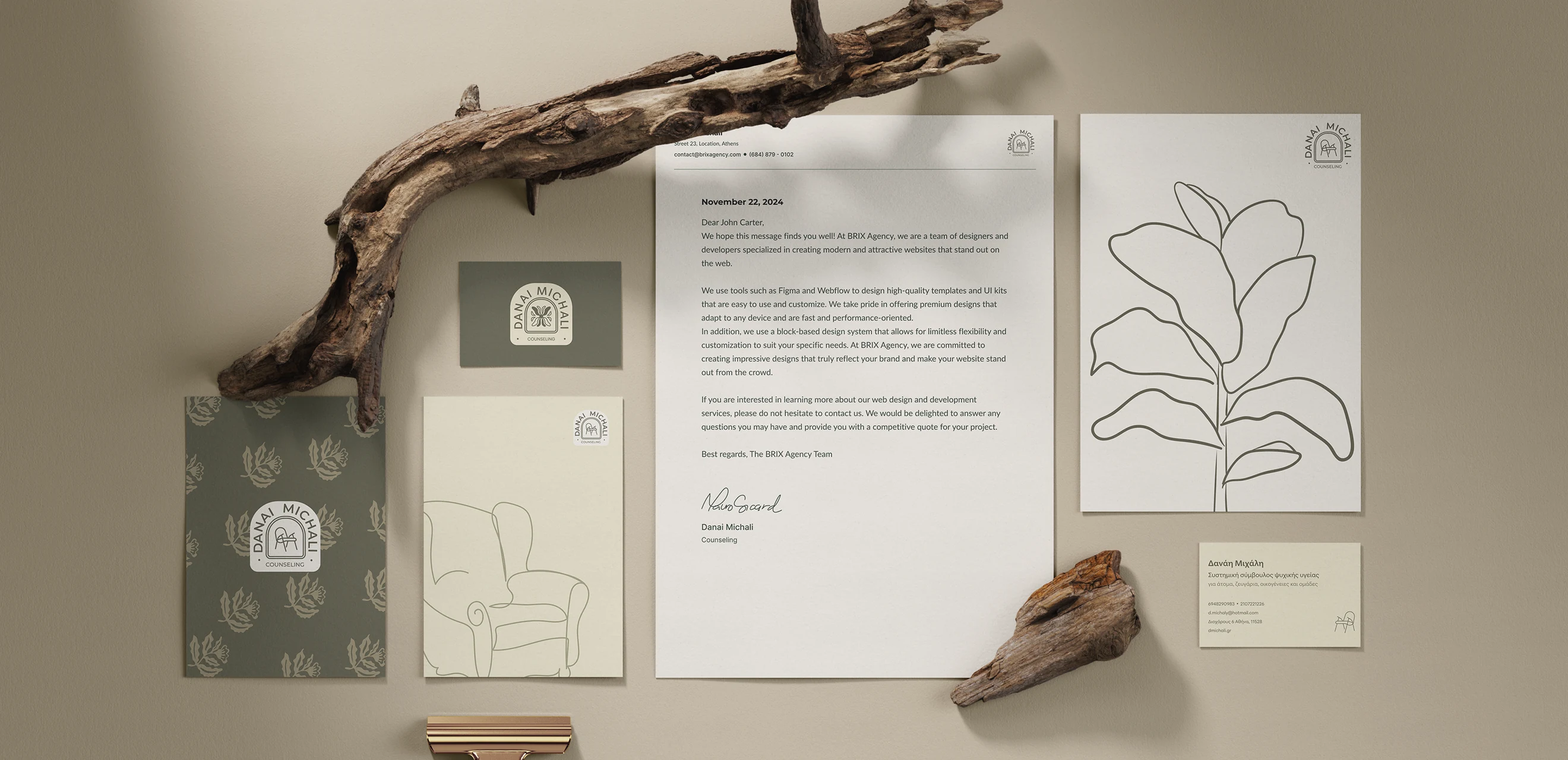 The whole stationery set laid flat - letterhead, notebook, patterned folder, a line drawing of a plant and the business cards