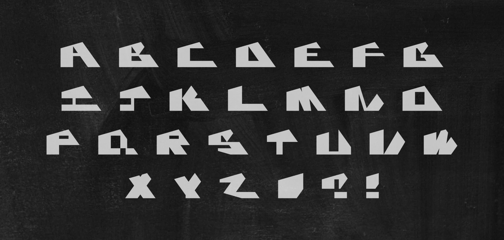 The full angular alphabet in pale grey on black - every letter cut from flat planes, with sheared diagonals in place of curves